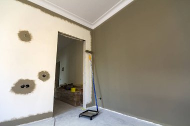 Silindir, boya ve tamir yapmak için araçlar boş daire salonunda. İnşaat ve tadilat kavramı.