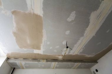 Oda onarım veya bina yeni ev veya apartement altında. Asma kaba beyaz tavan drywall değil noktalar sıva ile sona erdi ve elektrik ampulleri için kordonlar.