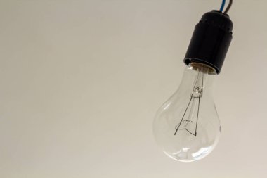 Fotoğrafı yalıtılmış elektrik ışık ampul gri arka plan üzerine kapatın. Enerji tasarrufu ve ekonomi kavramı.