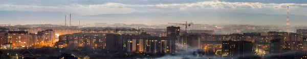 ウクライナ、イヴァーノ = フランキーウシク市の空中夜景のパノラマ。高層ビルの明るいライトでモダンな夜の街のシーン。住宅地や近代的な都市空間の建設用クレーン. — ストック写真