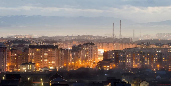Panorama de la vue aérienne nocturne de la ville d'Ivano-Frankivsk, Ukraine. Scène de ville nocturne moderne avec des lumières vives de grands bâtiments. Quais résidentiels et grues de chantier dans l'espace urbain moderne . — Photo