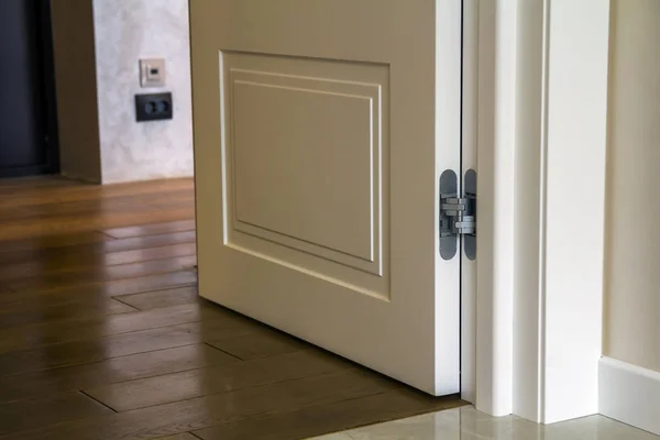 Detalhe interior da casa moderna com piso em parquet de madeira e porta branca. Apartamento após renovação close-up . — Fotografia de Stock