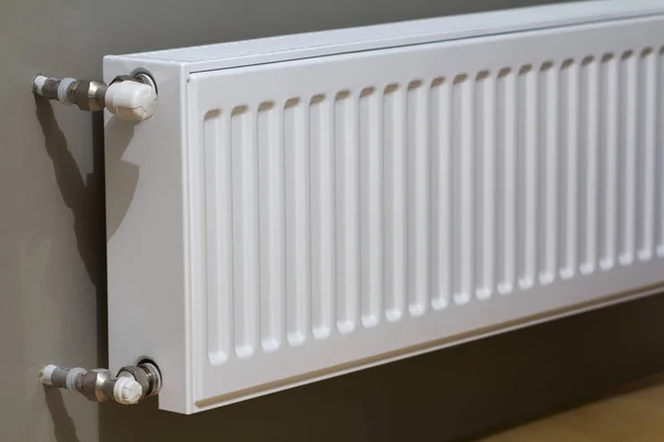 Radiador de aquecimento branco com válvula de termostato na parede em um interior de apartamento após obras de renovação . — Fotografia de Stock