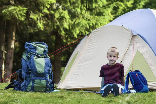 Holiday camping. Młody chłopak siedząc przed namiot w pobliżu backp — Zdjęcie stockowe