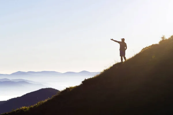 Ο άνθρωπος στην κορυφή του βουνού. Συναισθηματική σκηνή. Νεαρός άνδρας με backpac — Φωτογραφία Αρχείου