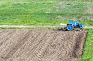 Mavi tozlu traktör kenarında duran fidelik Kültüvatör ile 