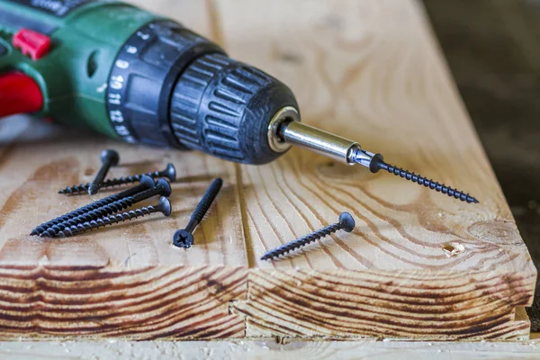 Close up de chave de fenda elétrica com alguns parafusos que colocam no velho — Fotografia de Stock