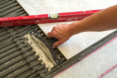 Seramik kiremit ve çatı ustası için araçlar. İşçi el yükleme yer karosu. Ev geliştirme, yenileme - Seramik Karo döşeme yapıştırıcı, harç, düzeyi