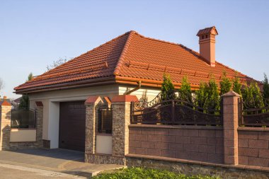 Shingle çatı, garaj ve demir ile taş çit arkasındaki bahçede yeşil ağaçlar ile yeni modern lüks pahalı konut Yazlık Ev kapısı sahte. Gerçek emlak, zenginlik ve refah kavramı.