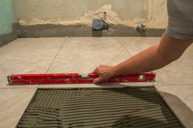 Seramik kiremit ve çatı ustası için araçlar. İşçi el yükleme yer karosu. Ev geliştirme, yenileme - Seramik Karo döşeme yapıştırıcı, harç, düzeyi.