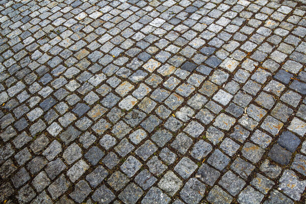 Abstract pattern of squared old-fashioned simple rough gray concrete street cobblestone pavement. Construction, decoration and background.