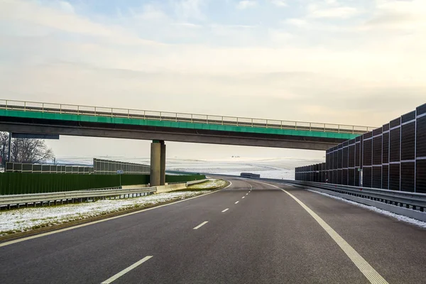 Современная широкая гладкая пустая асфальтовая магистраль, растянувшаяся до хребта — стоковое фото
