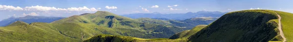 Panorama van de groene heuvels in zomer bergen met onverharde weg voor — Stockfoto
