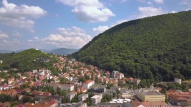 Romanya 'nın Transilvanya kentinde yer alan Brasov kentinin havadan görünüşü. Büyük Karpat dağlarıyla çevrili eski mimari yoğun yeşil ormanlarla kaplı..
