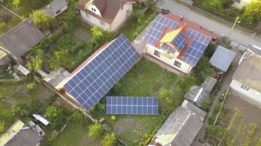 Çatıda güneş panelleri olan özel bir evin havadan görüntüsü. Fotovoltaik sistem inşa ve zemin üzerinde yenilenebilir enerji için.