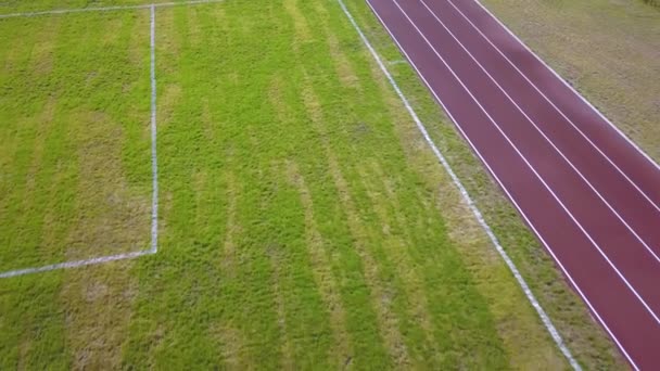 赤い走路と緑の芝生の芝生の上のビュー スポーツ活動のためのインフラ — ストック動画