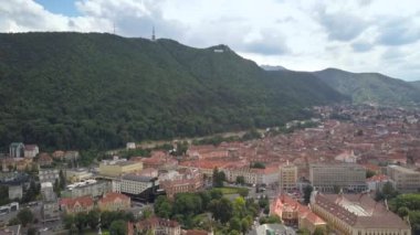 Romanya 'nın Transilvanya kentinde yer alan Brasov kentinin havadan görünüşü. Büyük Karpat dağlarıyla çevrili eski mimari yoğun yeşil ormanlarla kaplı..