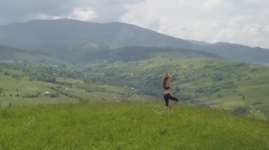 Genç kadın bir yaz günü dağ manzarasının tadını çıkarıyor. Doğa ortamında dinlenme ve meditasyon.