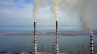 Kömür santralinden gelen gri dumanlı yüksek baca borularının havadan görüntüsü. Fosil yakıtla elektrik üretimi.
