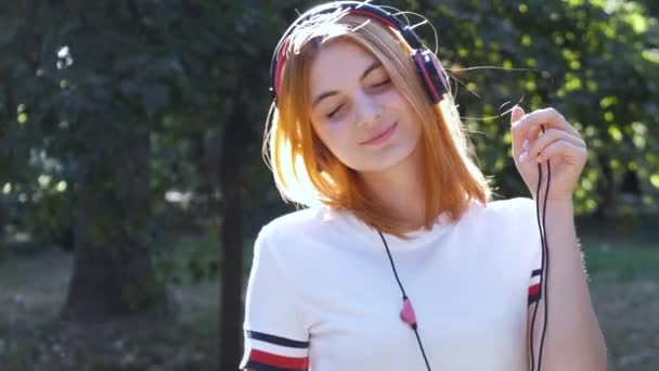 Linda Adolescente Con Pelo Rojo Escuchando Música Los Auriculares Aire — Vídeo de stock