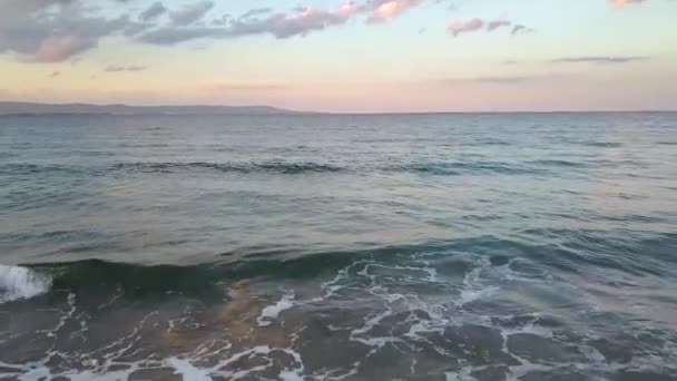 夕日の空の下で青い水の波と海の表面の空中写真 — ストック動画
