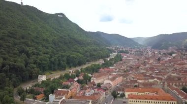 Romanya 'nın Transilvanya kentinde yer alan Brasov kentinin havadan görünüşü. Büyük Karpat dağlarıyla çevrili eski mimari yoğun yeşil ormanlarla kaplı..