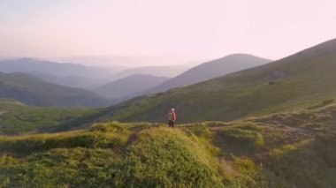 Sırt çantalı bir turist Carpathian dağlarında dağ yolunda koşuyor. Erkek turist kayalık çöl arazisinde koşuyor..