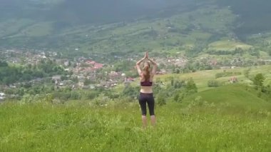 Genç kadın bir yaz günü dağ manzarasının tadını çıkarıyor. Doğa ortamında dinlenme ve meditasyon.