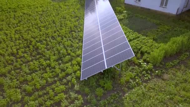 緑の草の上のクリーンエネルギーのための青い太陽電池パネル — ストック動画