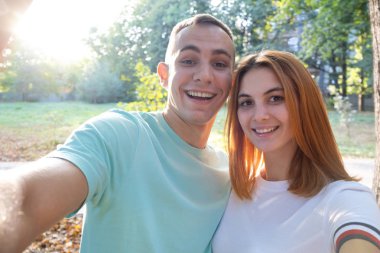 Sıcak ve güneşli bir havada selfie çeken mutlu genç çift..