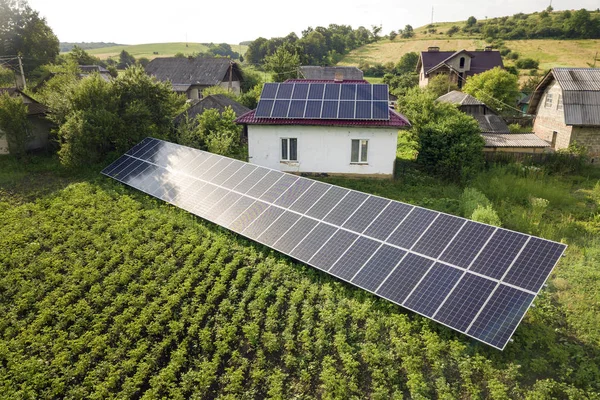 Widok z lotu ptaka na dom z niebieskimi panelami słonecznymi dla czystej energii. — Zdjęcie stockowe