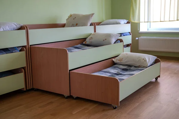 Πολλά μικρά κρεβάτια στον παιδικό σταθμό άδειο υπνοδωμάτιο. — Φωτογραφία Αρχείου