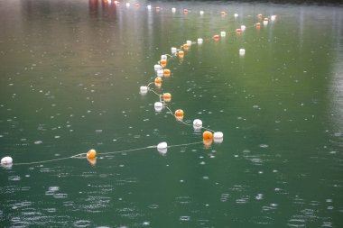 Su yüzeyinde beyaz ve sarı kısıtlama işaretleri olan halat 