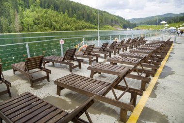 Su kenarında boş ahşap plaj sandalyeleri Satır.