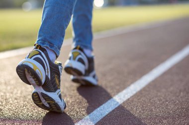 Spor ayakkabılı kadın ayaklarını kapat ve kot pantolon giy.
