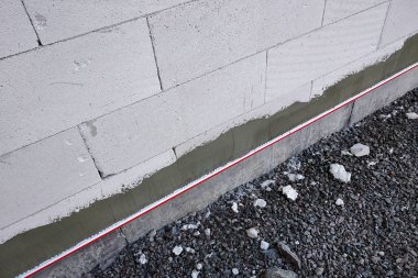 Yapım çalışmaları kapsamında beyaz blok bina cephesi.