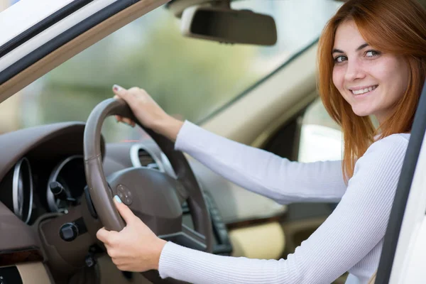 Молодая женщина с рыжими волосами водит машину . — стоковое фото