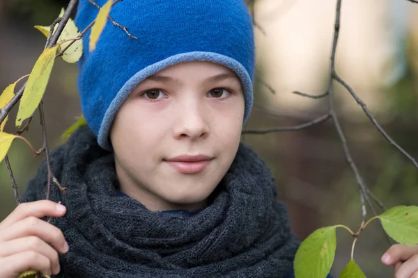 Гарненький хлопчик в теплому зимовому одязі, що тримає гілку дерева — стокове фото