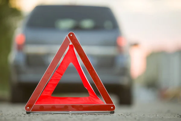 Triângulo de emergência vermelho parar sinal e carro quebrado em uma rua da cidade — Fotografia de Stock