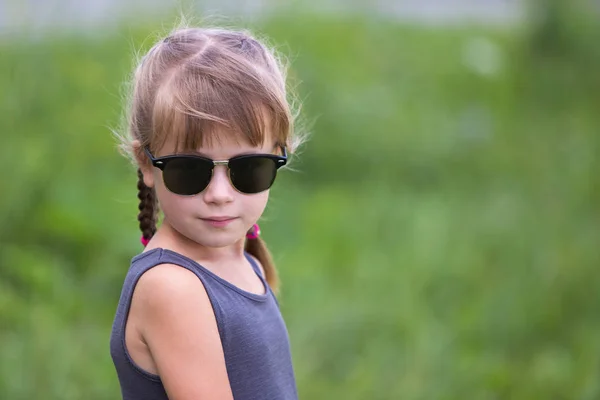 Porträtt av söt barn flicka med flätor i håret utomhus i su — Stockfoto