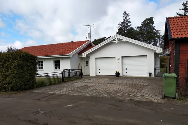 White new garage for two cars and wooden barn on private house y