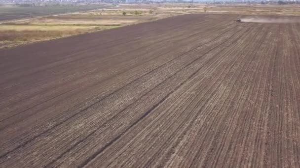 地面を耕し 乾燥したフィールドを播種緑のトラクターの空中ビューをトップダウン 早春の苗前活動の一環として 苗の栽培者と土地を準備する農家 — ストック動画