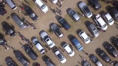 Park etmiş birçok arabanın ve araba pazarında veya otoparkta yürüyen müşterilerin hava manzarası..