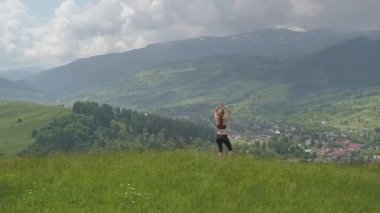 Genç kadın bir yaz günü dağ manzarasının tadını çıkarıyor. Doğa ortamında dinlenme ve meditasyon.
