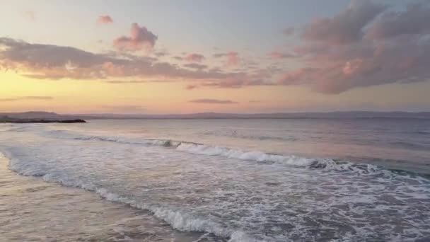 夕日の空の下で青い水の波と海の表面の空中写真 — ストック動画