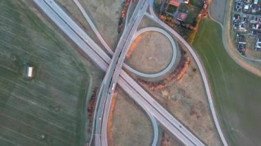 Hareket halindeki trafik arabalarıyla otoyol kesişiminin yukarıdan aşağı hava görüntüsü. 