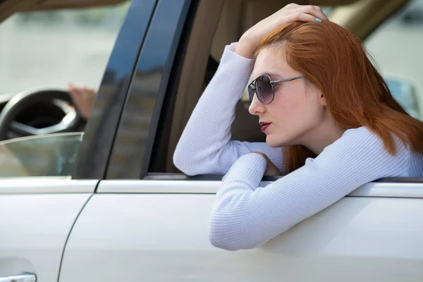 Mujer joven con pelo rojo y gafas de sol viajando en coche. Pas — Foto de Stock