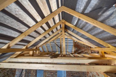 İnşaat halindeki bir binanın tavanarası. Ahşap kirişli.