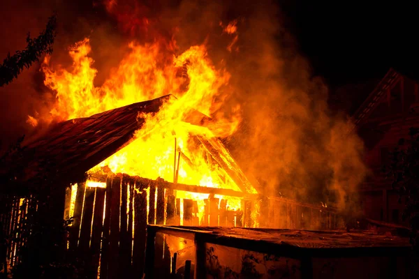 Holzhaus oder Scheune brennt in der Nacht. — Stockfoto
