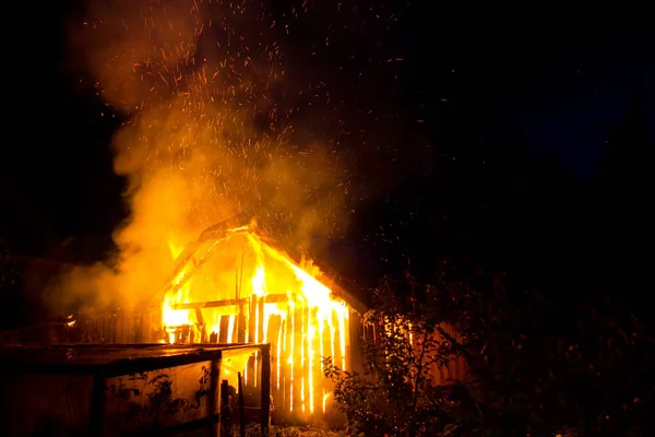 Casa de madera o granero ardiendo en llamas por la noche . — Foto de Stock